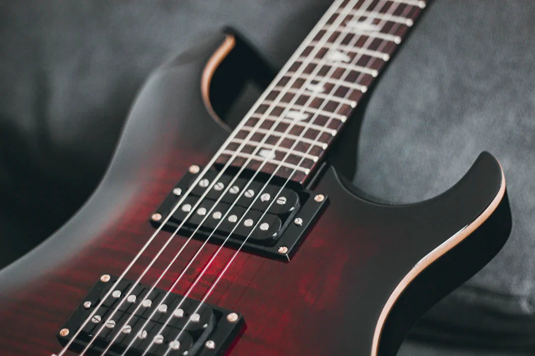 Close-up of high-end American electric guitar with red and black finish and dual pickups
