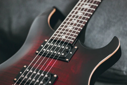 Close-up of high-end American electric guitar with red and black finish and dual pickups