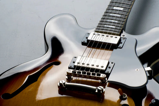 Close-up of a high-end semi-hollow body electric guitar with sunburst finish and dual humbuckers