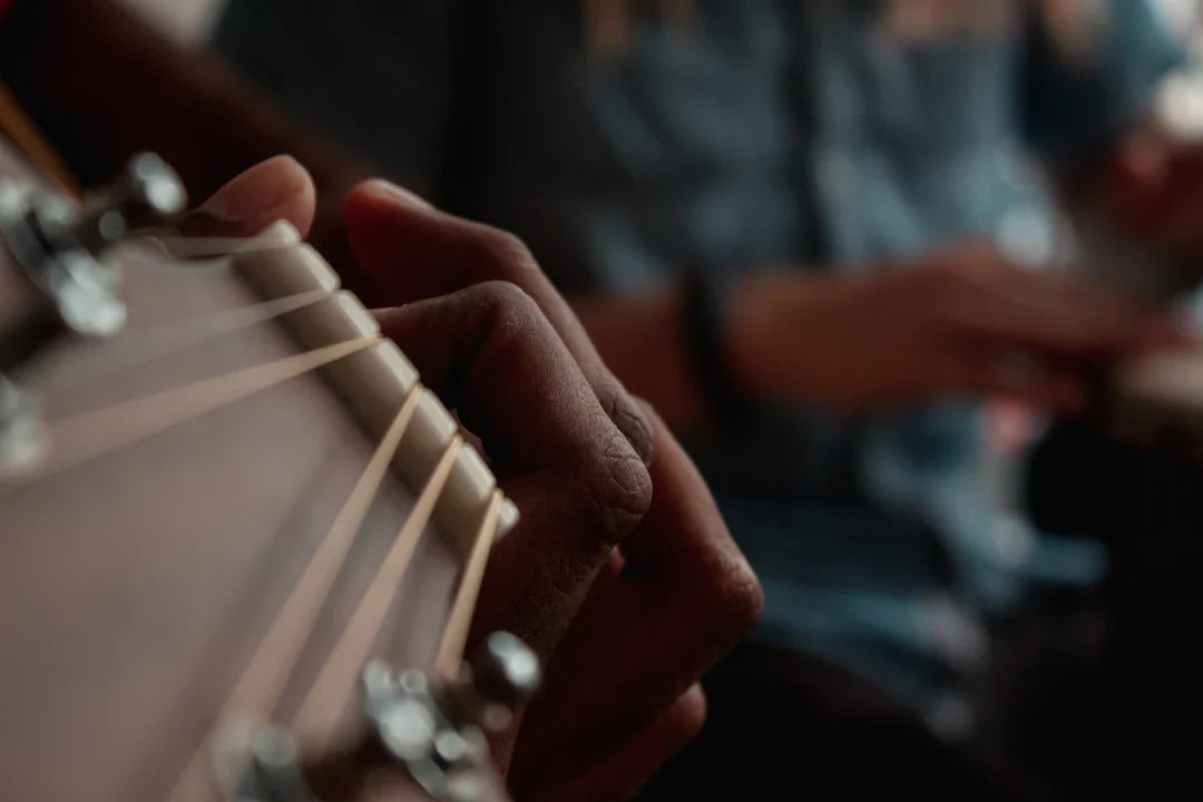 Close-up of hand playing high-end electric guitar, focus on strings and fretboard.