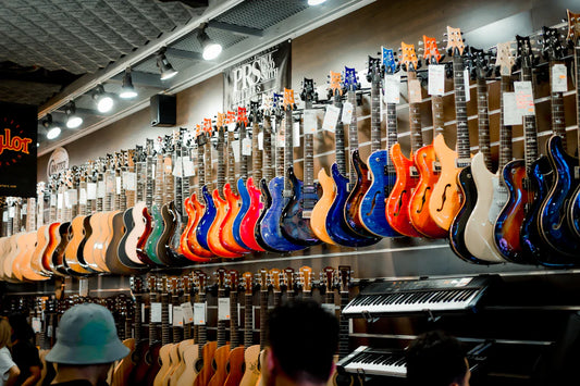 Wall display of colorful electric and acoustic guitars in a music store setting